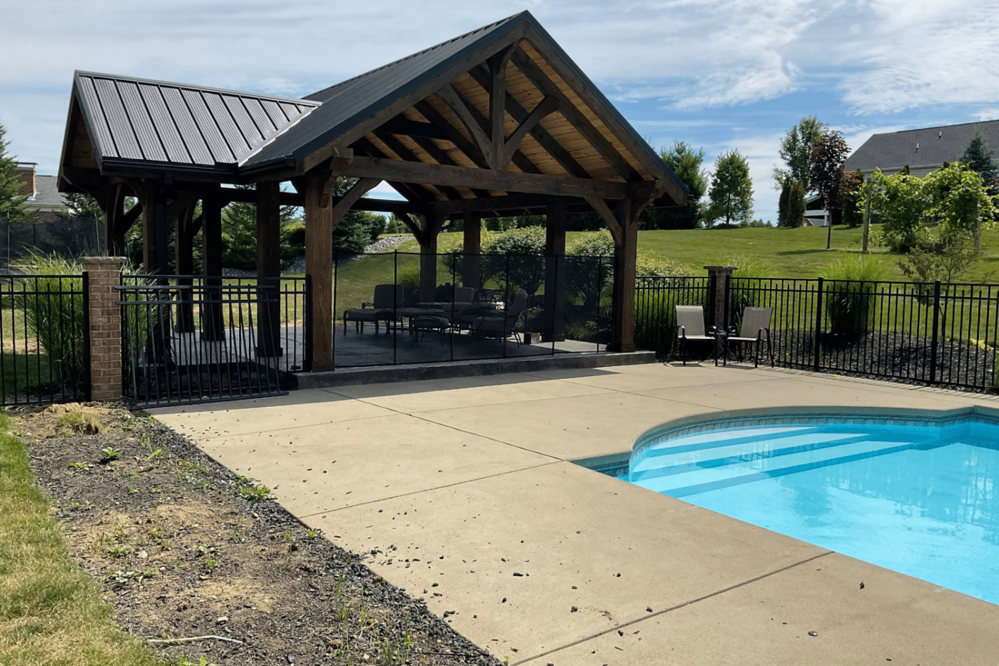 Pavilion with sitting area underneath near a pool