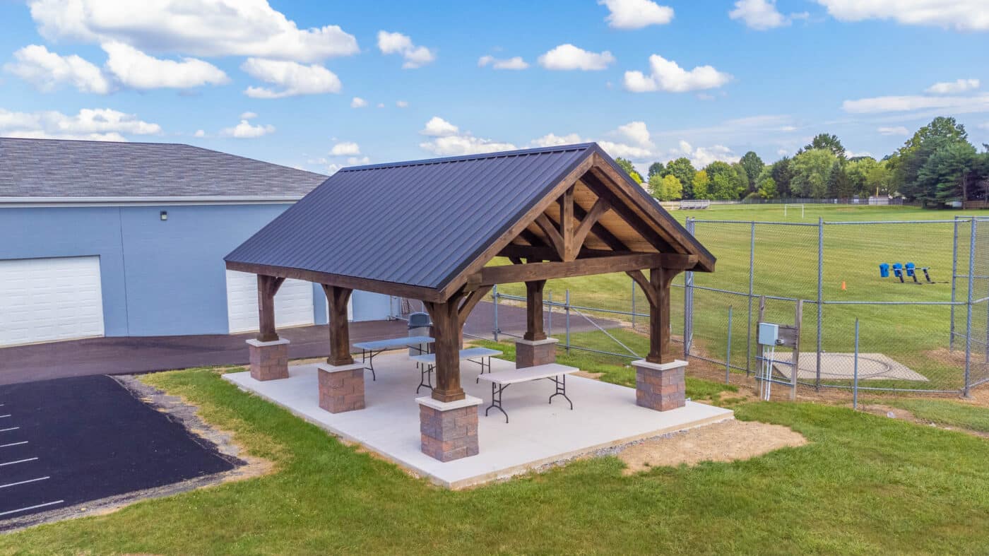 A-frame pavilion with tables underneath built for a school near a field in Seneca, PA